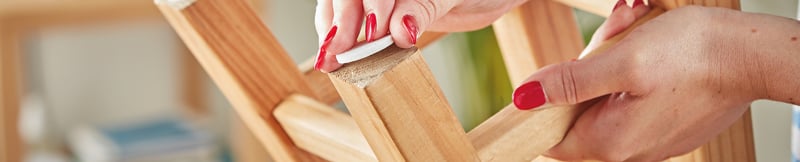 Woman placing felt pads on the bottom of a stool